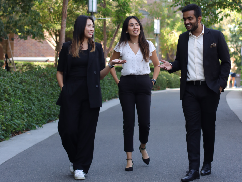 Trinh, Saldana, and Sharma walking and talking together.