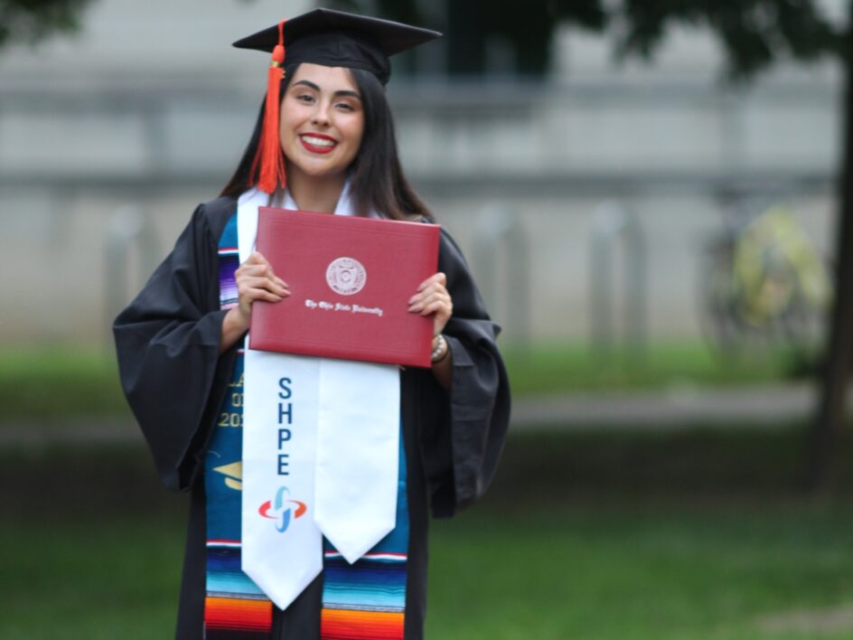 Saldana in a cap and gown with a stole with the letters SHPE.