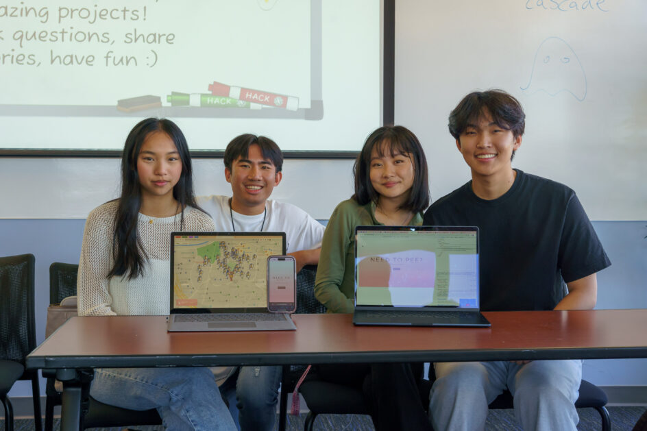 ZotWee members behind devices displaying their project.