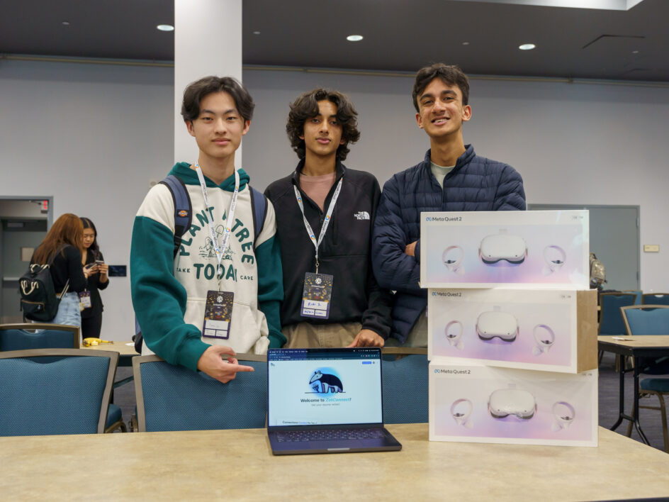 Three guys standing behind a laptop that says ZotConnect on the screen