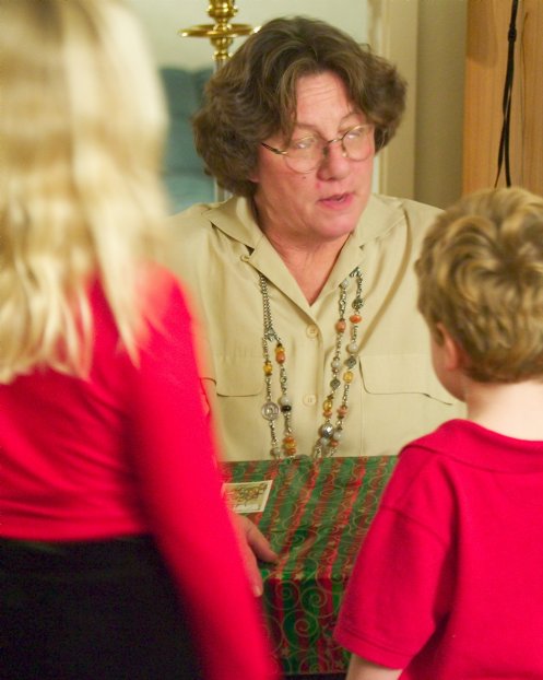 Phyllis opens a present as the kids watch